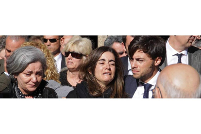 Loreto, la hija de Isabel Carrasco, se apoya en su novio desconsolada al acabar el funeral por su madre oficiado en la Catedral de León