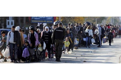 Cientos de refugiados esperan para registrarse en el campamento de Preshevo, en Serbia, este domingo