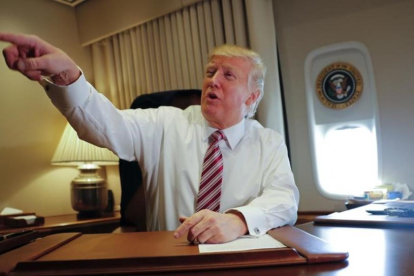 Trump señala a miembros de la prensa, sentado en su despacho del Air Force One, el 26 de enero.