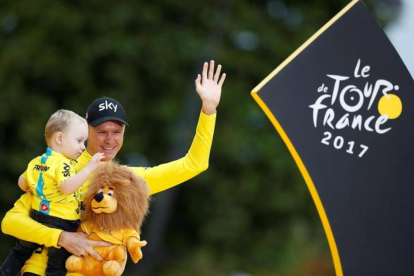 Chris Froome con su hijo, en el podio de París.