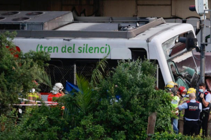 Miembros de los servicios de emergencia y agentes de los Mossos d'Esquadra asisten al lugar en el que se produjo un choque entre un tren de mercancías y uno de pasajeros entre las estaciones de Sant Boi de Llobregat y Molí Nou de la línea Llobregat-Anoia de Ferrocarrils de la Generalitat de Catalunya (FGC), este lunes. Una persona ha fallecido y otras 85 han resultado heridas, dos en estado menos grave y 83 leves. QUIQUE GARCÍA