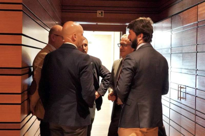 Gallardo conversa con el consejero Veganzones y procuradores de Vox en los pasillos de las Cortes. LETICIA PÉREZ