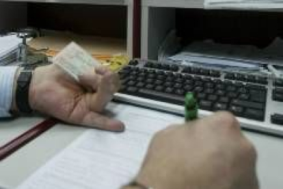 Un funcionario procede a comprobar los datos de un contribuyente en una gestión de pago de impuestos