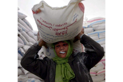Una mujer palestina recibe un saco de comida del programa de alimentos. MOHAMMED SABER