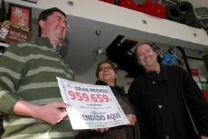 Los propietarios del estanco y el delegado de apuestas en León (dcha), muestran el número premiado