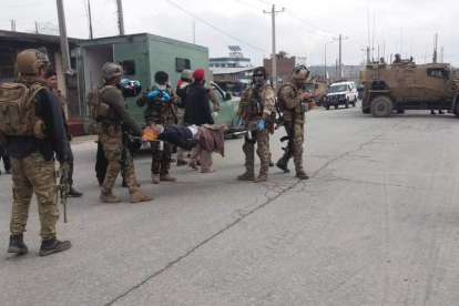 Los soldados afganos trasladan a uno de los heridos.