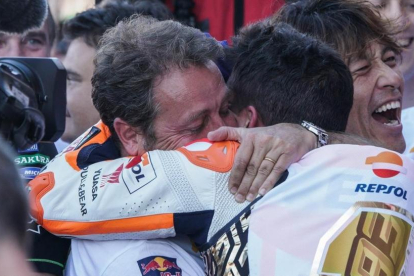 Emilio Alzamora, visiblemente emocionado, abraza y felicita a su pupilo, Marc Márquez, tras la conquista de su sexto título mundial de motociclismo en Valencia.