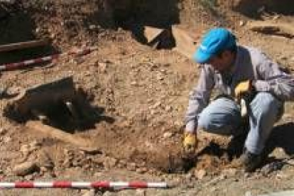 Uno de los arqueólogos limpia los restos de una de las tumbas
