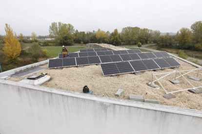 Un operario coloca las placas fotovoltaicas del plan piloto de la UE en el tejado del Ayuntamiento de Sariegos. MARCIANO PÉREZ