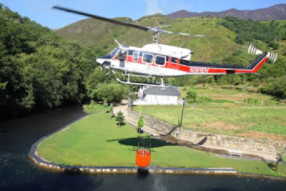 Un helicóptero recoge agua durante las tareas de extinción del incendio forestal