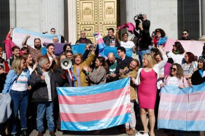 La ministra de Igualdad Irene Montero (c) celebra con miembros del colectivo LGTBI la aprobación de la Ley Trans en el Congreso de los Diputados en Madrid, el 16 de febrero. EFE/JAVIER LIZÓN