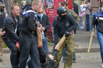 Manifestantes prorrusos cargan con un compañero herido durante los enfrentamientos con los partidarios de una Ucrania unida en la ciudad de Odesa.