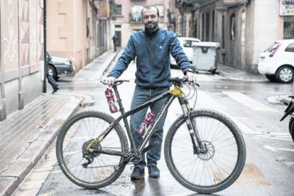 Ernesto Romero, con su 'mountain bike', en la Barceloneta.