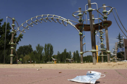 Mascarillas tiradas por el suelo cerca de un parque infantil en León. FERNANDO OTERO