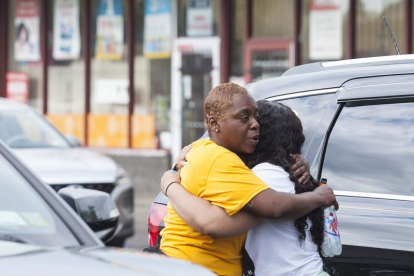 Dos mujeres se abrazan a la entrada del súper en el que ocurrió la matanza. BRANDON WATSON