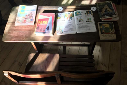 Un pupitre de una vieja escuela, con los libros de hace algunas décadas.