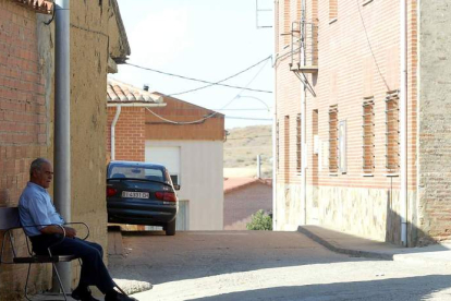 Un vecino sentado en el banco de un pueblo afectado por la despoblación. RAMIRO