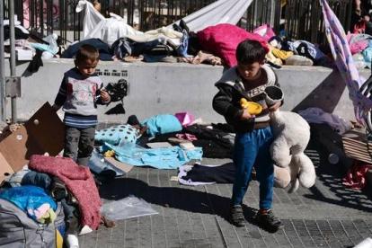Unos niños buscan sus juguetes en la plaza Victoria de Atenas antes de ser trasladados a las instalaciones olímpicas.