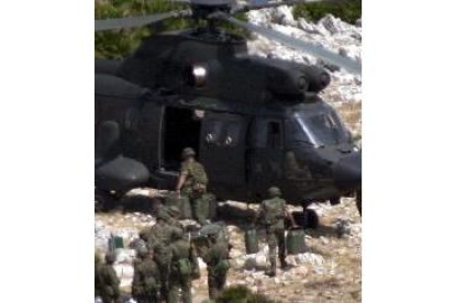 Los legionarios destacados en Perejil suben el material militar a un helicóptero y abandonan la isla