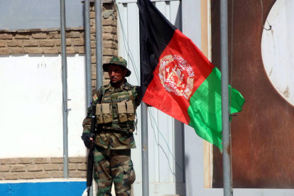 Soldado afgano izando una bandera de Afganistán en Camp Arena, base entregada por Italia en 2020. EFE/ JALIL REZAYEE