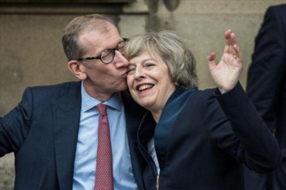 Theresa May recibe un beso de su marido, Philip John May, en el Palacio de Westminster