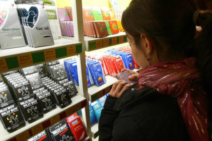 Una chica, frente a un estante repleto de preservativos en una tienda especializada de Barcelona.