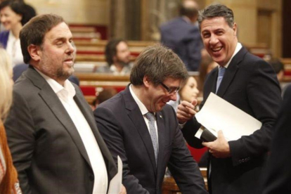 El líder del PPC en el Parlament, Xavier García Albiol, saluda al 'president' Carles Puigdemont, antes de una sesión de control en el Parlament.