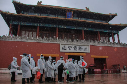 Trabajadores esperan en la nieve, en Pekín, para cumplir uno de los protocolos de las empresas. WU HONG
