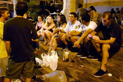 Un grupo de jóvenes hace botellón en una plaza de Barcelona.