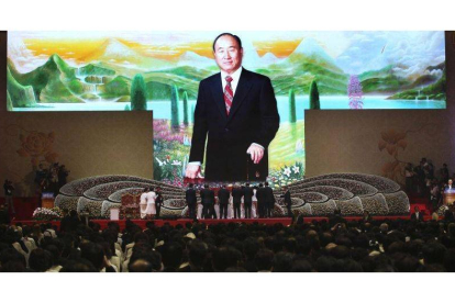 Familiares y amigos realizan una ofrenda floral durante la misa celebrada con motivo del primer aniversario de la muerte de su fundador, el reverendo Sun Myung Moon.