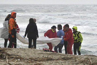 Los equipos de Cruz Roja sacan del mar el cadáver de uno de los migrantes. GIUSEPPE PIPITA