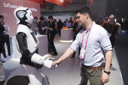 Un asistente saluda a un robot en el último Mobile World Congress.