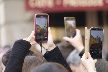 Varias personas captan con sus móviles imágenes de la Semana Santa leonesa. MARCIANO PÉREZ