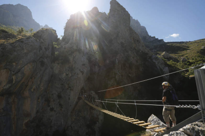 Un puente tibetano de 35 metros, estrecho y que cuelga a 30 metros sobre el río Cares, inicia el recorrido de la Vía Ferrata desde Cordiñanes. Enclavada en el Parque de Picos de Europa, la ruta supera un desnivel de 300 metros y dispone de zona de escalad