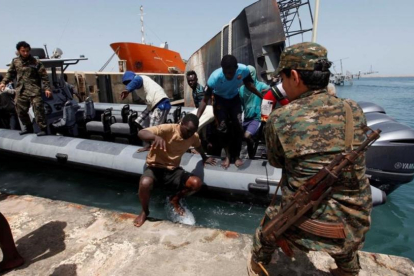 Inmigrantes llegan a la base naval libia después de haber sido rescatados por guardacostas libios en la costa de Trípoli.