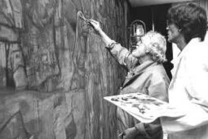 Vela Zanetti, con uno de sus colaboradores, pintando un mural