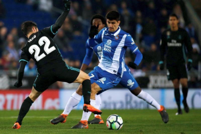 El delantero del Espanyol, Gerard Moreno (d), pelea un balón con el centrocampista del Real Madrid, Isco Alarcón (i), durante el partido de la vigesimosexta jornada de liga que se disputa en el RCDE Stadium.