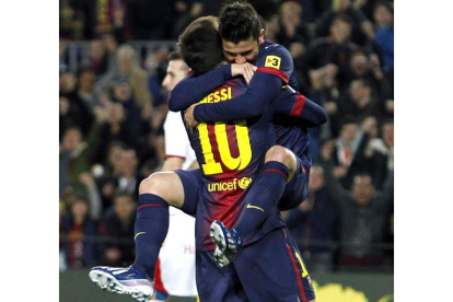 Lionel Messi abraza a su compañero, el delantero David Villa, tras el gol del asturiano.