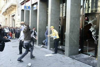 Un manifestante reprocha su acción a un violento tras la rotura de cristales de una sucursal bancaria. Foto: JULIO CARBÓ