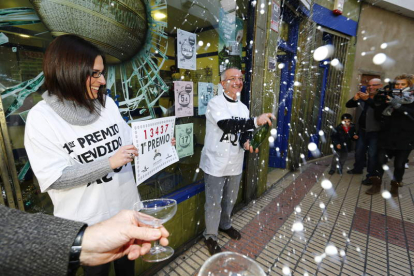 Carlos Manso y su hija Cristina celebran con champán delante de su administración en Boñar el Primer Premio de la Lotería de Navidad.