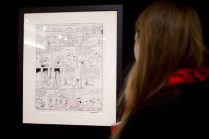 Una mujer mira la plancha de Astérix subastada a beneficio de los familiares de los dibujantes de 'Charlie Hebdo'.