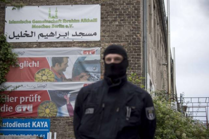 Un oficial de la policía alemana espera fuera de una asociación musulmana supuestamente vinculada a una trama de apoyo al yihadismo en Siria.