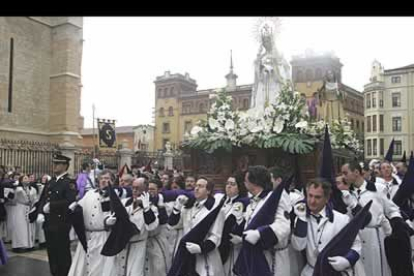 Una fila de hermanos del Divino Obrero servía como presentación del paso de La Soledad realizado por Víctor de los Ríos 1958 - 60 con escolta de la Policía Local de León.