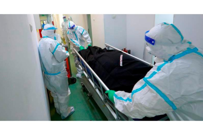 Trabajadores sanitarios sacan a un fallecido en un hospital de Rumanía. ROBERT GHEMENT