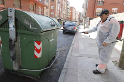 Un trabajador del Servicio Municipal de Limpieza de León desinfecta un contenedor.