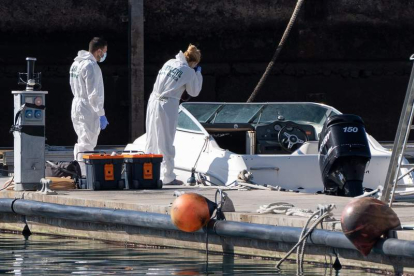 Dos miembros de la policía científica analizan el barco encontrado a la deriva. RAMÓN DE LA ROCHA