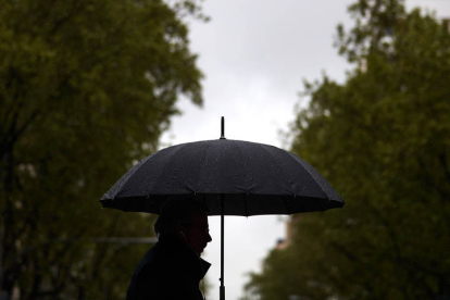 Un hombre se protege de la lluvia con un paraguas.  MIGUEL OSES