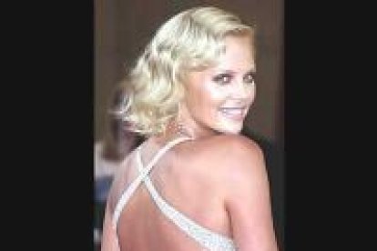<b>Charlize Teron</b> se presentó con un impresionante vestido blanco con escote a la espalda.