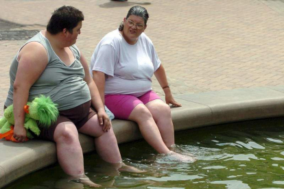 Dos personas se refrescan en una fuente en Inglaterra. KIYOSHI OTA
