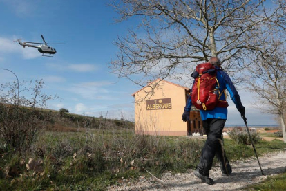 Un peregrino llega a Reliegos bajo la vigilancia de la Unidad Aérea de la Guardia Civil en un trabajo del plan de seguridad en el Camino de Santiago. JESÚS F. SALVADORES